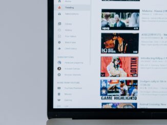 Person browsing YouTube videos on a laptop, showcasing modern technology and online content.