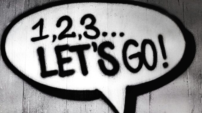 Black and white street art featuring a bold motivational message in a speech bubble.