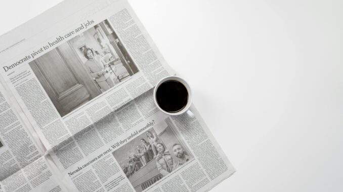 A fresh cup of coffee resting on a newspaper, perfect morning routine setup.