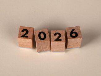 Wooden cubes forming the year 2026 on a neutral background.