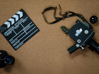 Vintage camera and clapboard on a cork board evoke a classic filmmaking vibe.