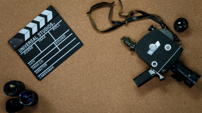 Vintage camera and clapboard on a cork board evoke a classic filmmaking vibe.