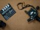 Vintage camera and clapboard on a cork board evoke a classic filmmaking vibe.