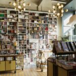 Bright and inviting bookstore interior featuring tall bookshelves filled with diverse books and a whimsical ceiling decor.