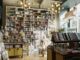 Bright and inviting bookstore interior featuring tall bookshelves filled with diverse books and a whimsical ceiling decor.