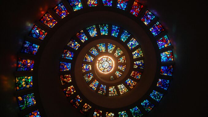 Captivating spiral stained glass art with vibrant colors forming a dramatic eye-catching pattern.