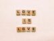 Wooden letter tiles forming 'Love is Love', symbolizing inclusion and pride.
