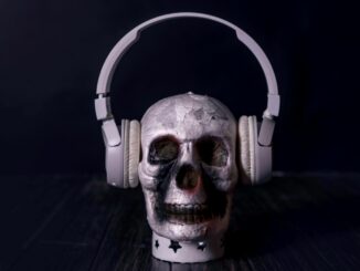 A creepy skull adorned with headphones, casting an eerie vibe against a black background.