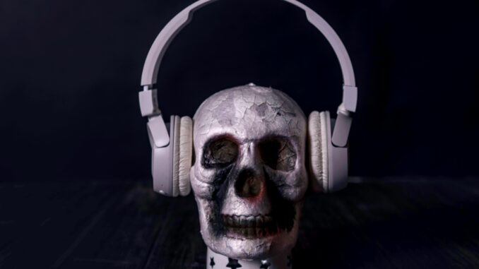 A creepy skull adorned with headphones, casting an eerie vibe against a black background.