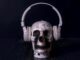 A creepy skull adorned with headphones, casting an eerie vibe against a black background.