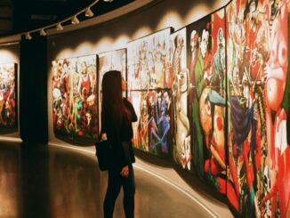 A woman observes vibrant paintings in an art gallery exhibition.