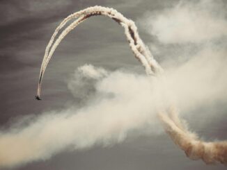A thrilling airplane performing acrobatics in the sky with smoke trails.