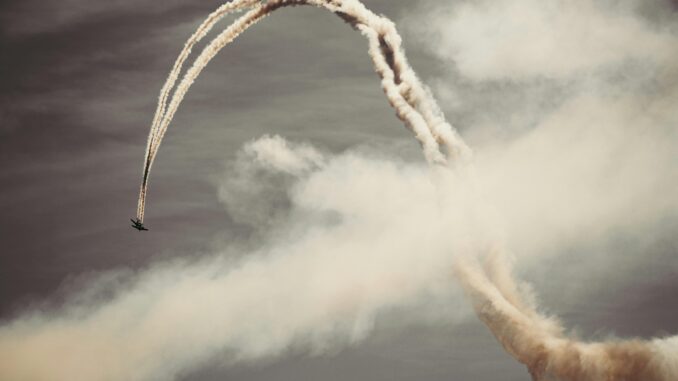 A thrilling airplane performing acrobatics in the sky with smoke trails.