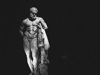 Striking black and white photo of a Hercules sculpture with dramatic lighting effect.