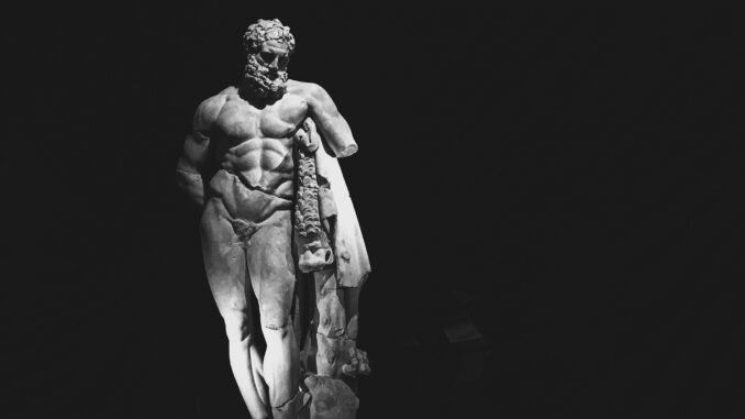 Striking black and white photo of a Hercules sculpture with dramatic lighting effect.