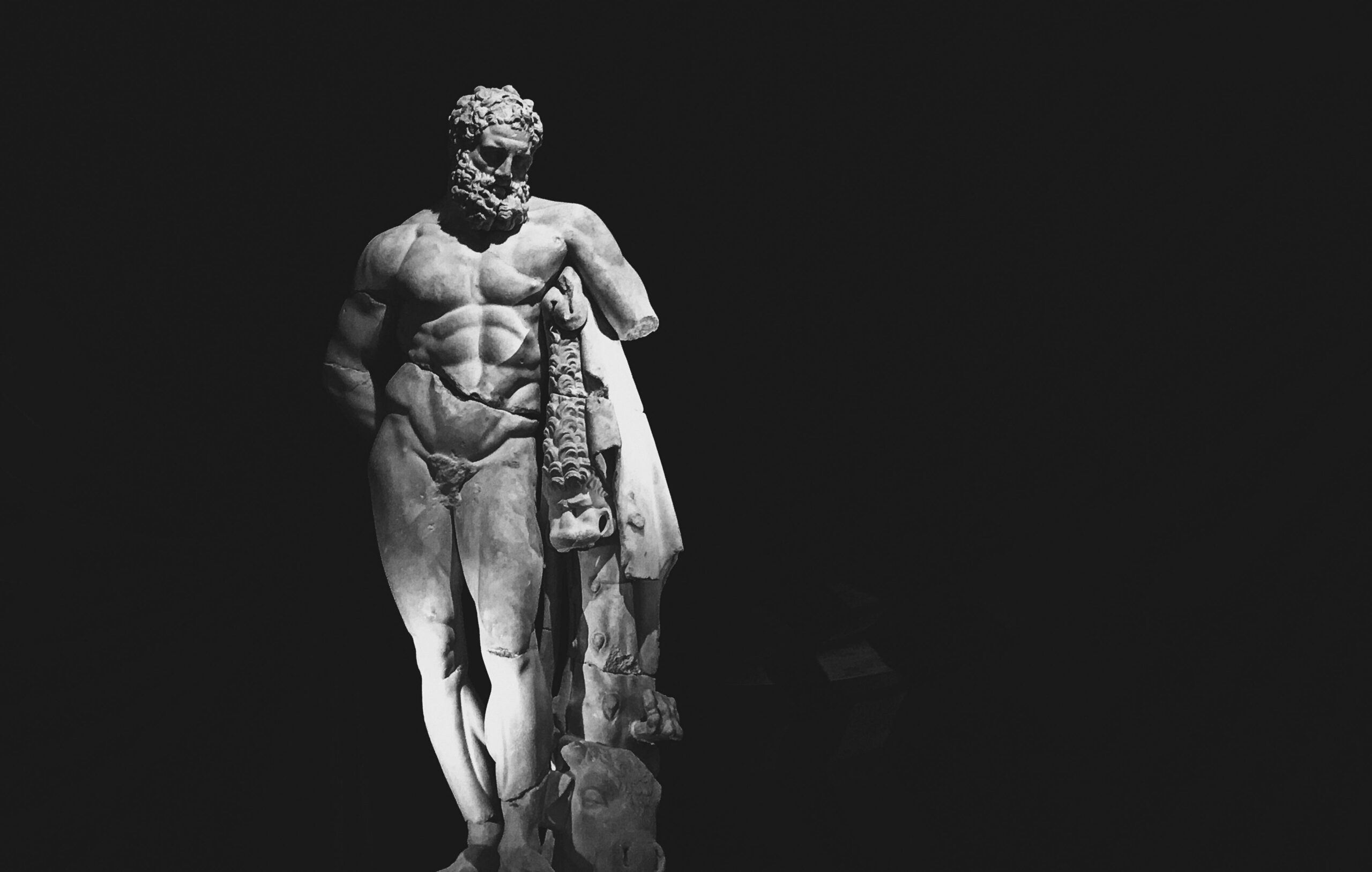 Striking black and white photo of a Hercules sculpture with dramatic lighting effect.