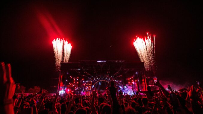 Thrilling concert scene with fireworks and vibrant crowd at night.