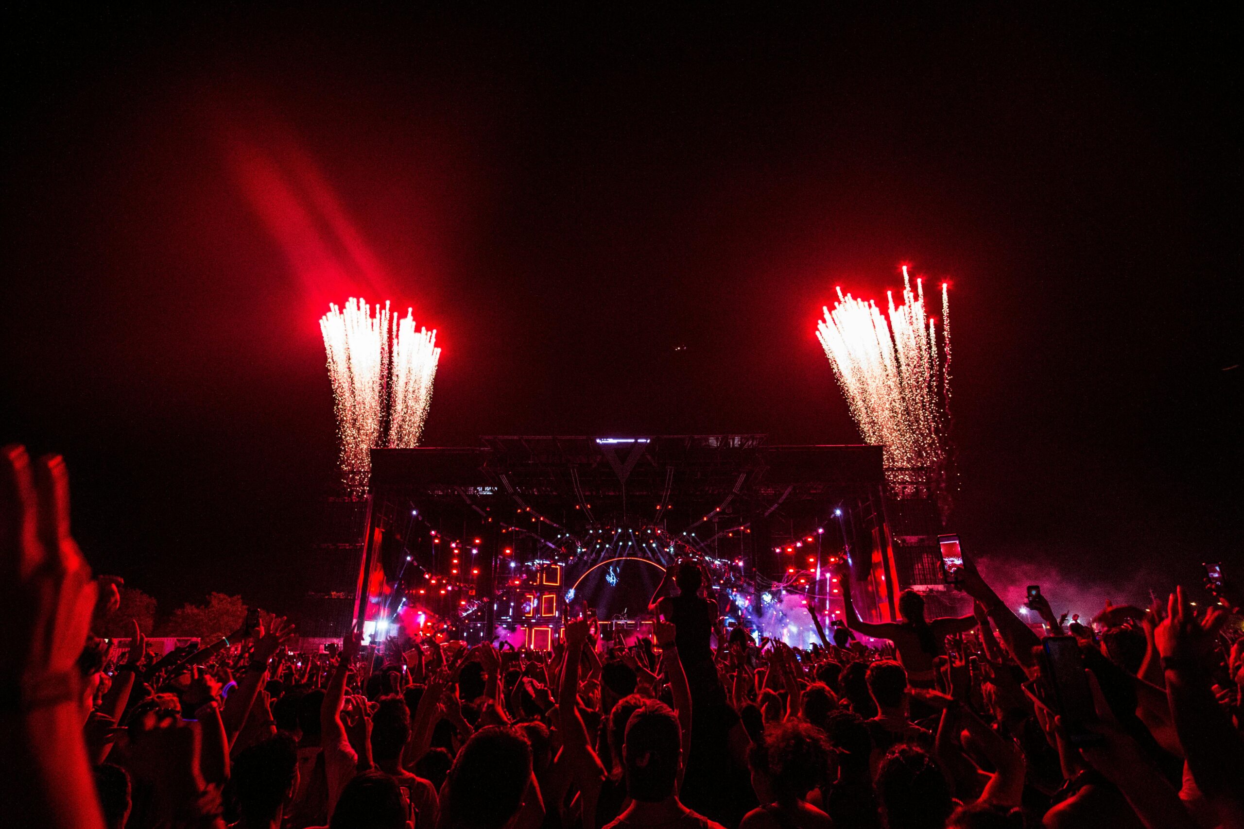Thrilling concert scene with fireworks and vibrant crowd at night.
