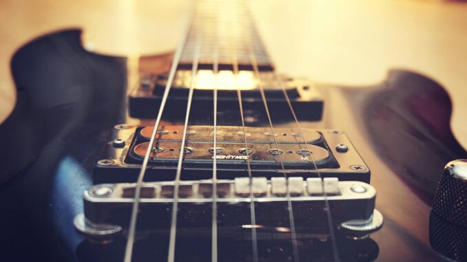 Detailed close-up of electric guitar strings and bridge, highlighting musical craftsmanship.