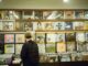 Young man browsing vinyl records in a vintage music store, exploring musical classics.