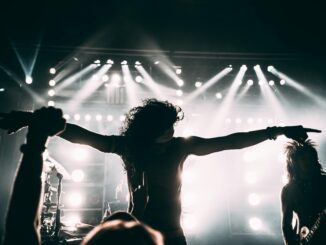 Energetic rock band performance with striking stage lights and silhouettes.