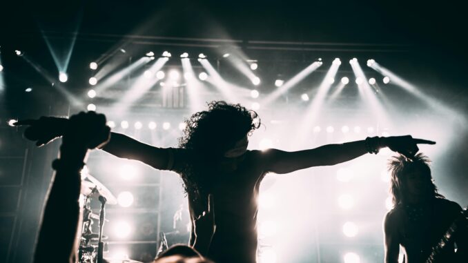 Energetic rock band performance with striking stage lights and silhouettes.