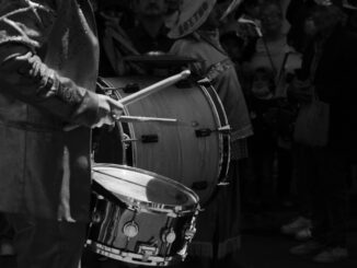 Black and white image of a drummer in a parade, creating rhythm in Pachuca de Soto.