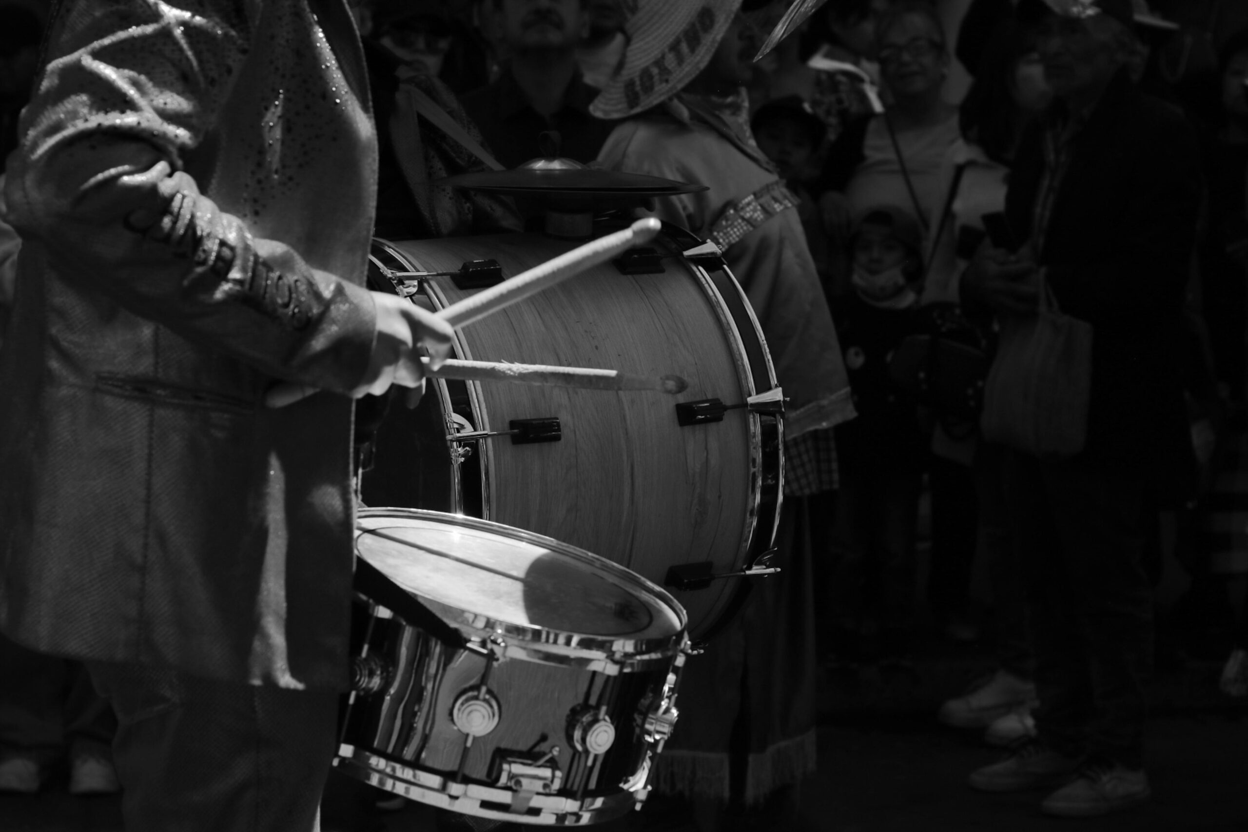 Black and white image of a drummer in a parade, creating rhythm in Pachuca de Soto.