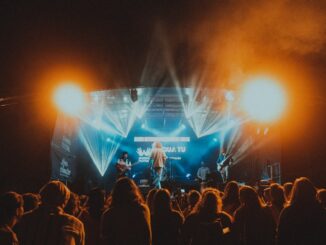 Energetic live music performance at night with a lively crowd.