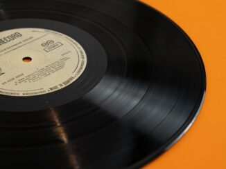 A classic vinyl record displayed against a bright yellow backdrop, embodying retro nostalgia.