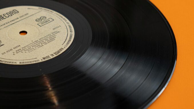 A classic vinyl record displayed against a bright yellow backdrop, embodying retro nostalgia.