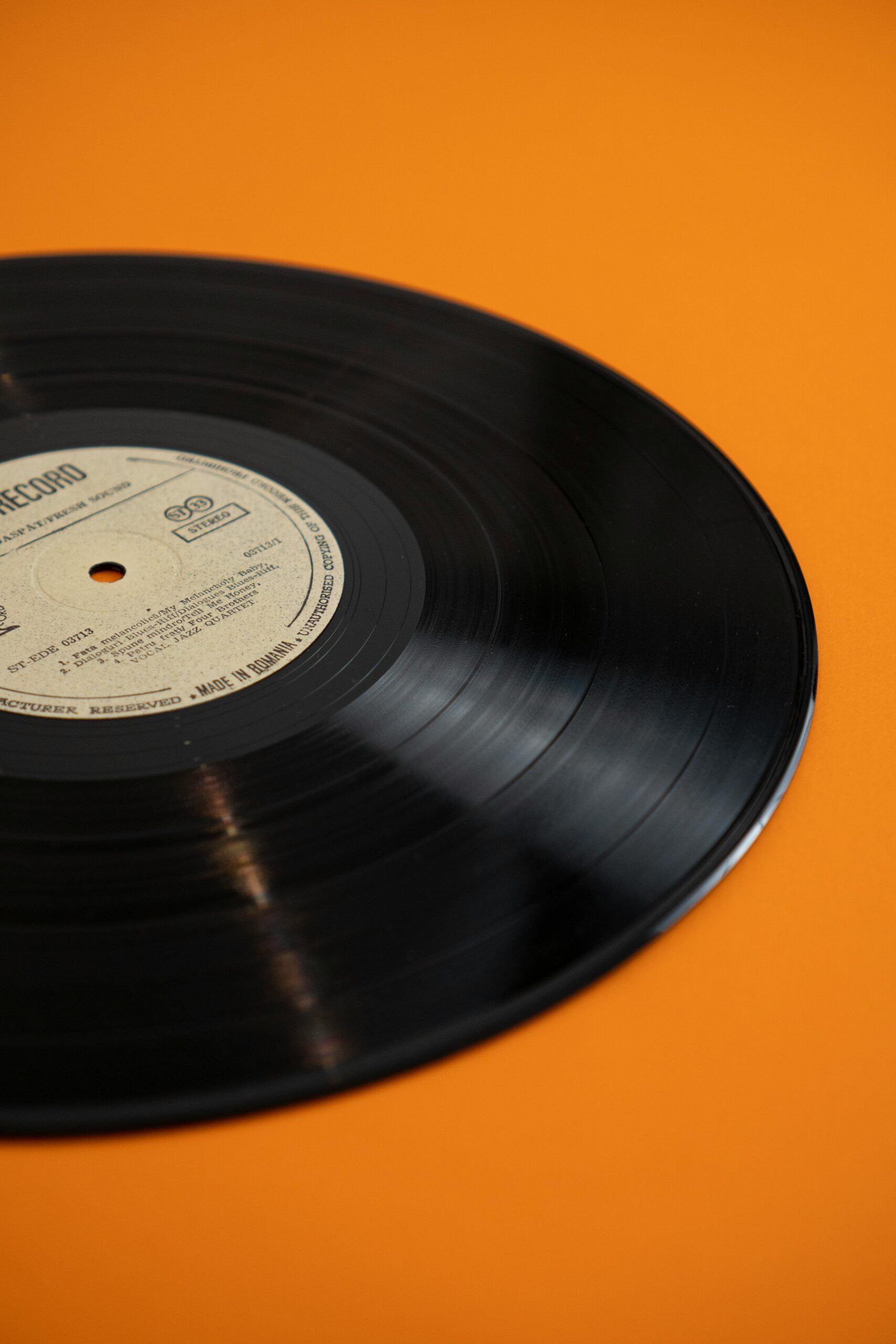 A classic vinyl record displayed against a bright yellow backdrop, embodying retro nostalgia.