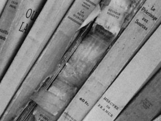 Close-up of vintage books in a monochrome library, showcasing aged book spines and classic typography.