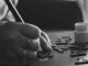 Black and white photo of hand crafting with wooden letters and paint.