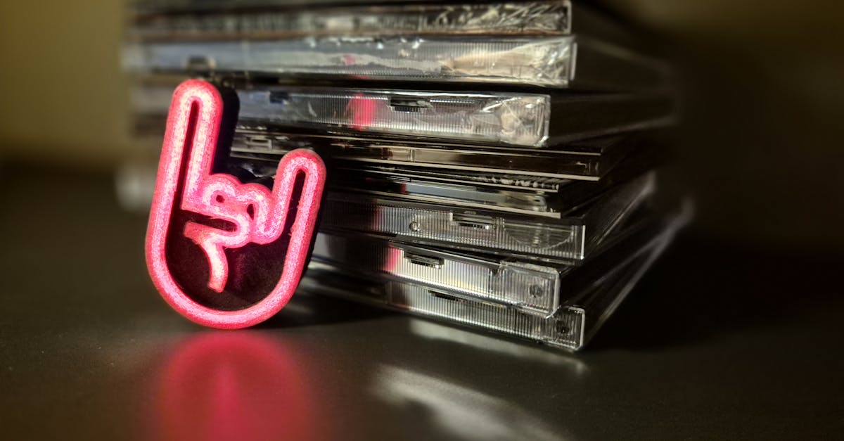 A vibrant rock hand symbol next to a stack of compact discs, reflecting music culture.