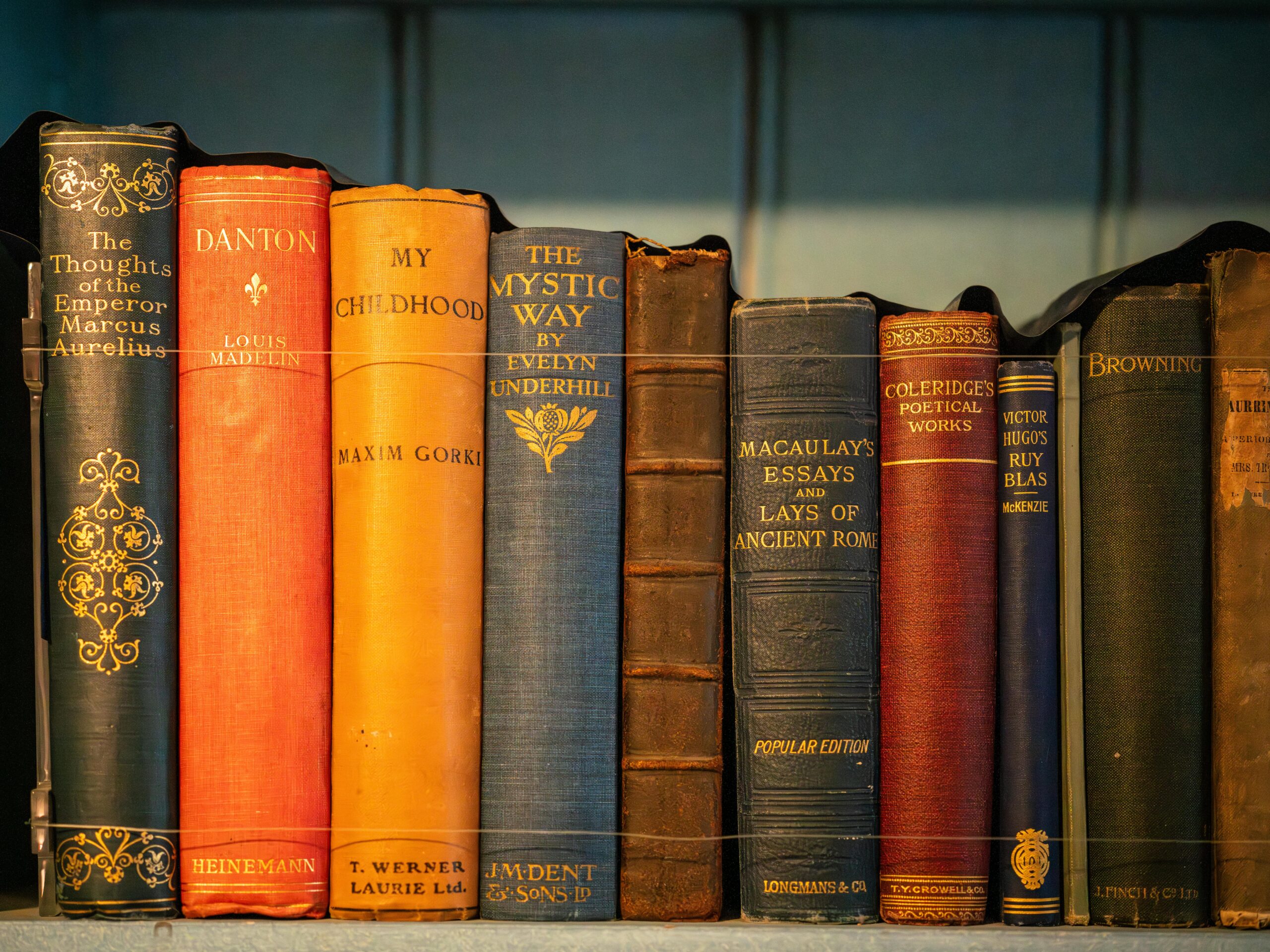 A row of vintage hardcover books with elegant bindings and classic literature titles.