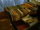 A collection of vintage hardcover and paperback books organized on a wooden table.