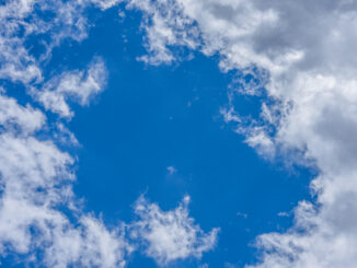 Vibrant blue sky with scattered fluffy white clouds, perfect for backgrounds or wallpapers.