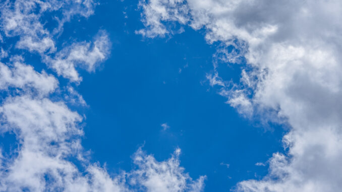 Vibrant blue sky with scattered fluffy white clouds, perfect for backgrounds or wallpapers.