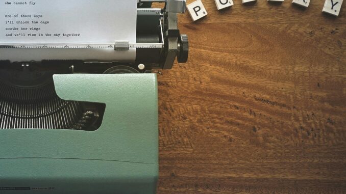 A typewriter creates poetic lines on paper amidst Scrabble tiles spelling 'POETRY'.