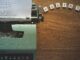 A typewriter creates poetic lines on paper amidst Scrabble tiles spelling 'POETRY'.