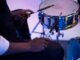 A musician playing a snare drum with drumsticks in a studio setting. Close-up view.