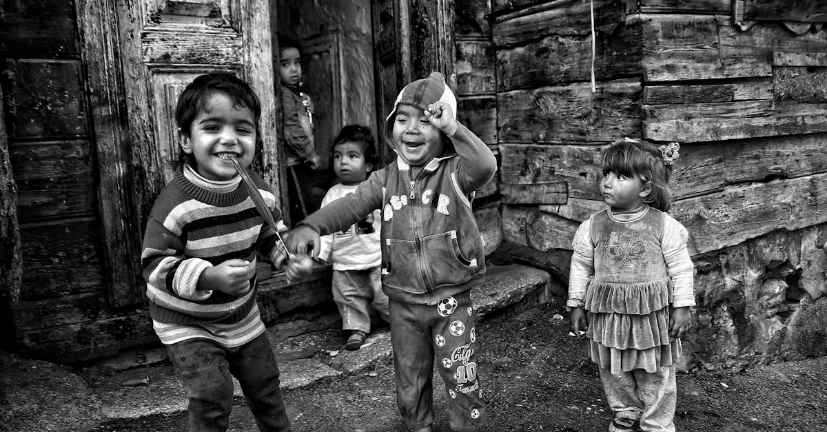 Joyous children playing on a rustic porch, captured in black and white.