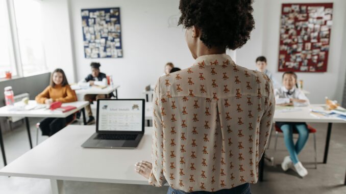 Female teacher engaging students in a classroom setting with diverse learners.