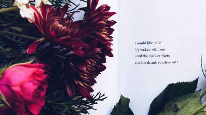 A beautiful floral arrangement alongside an introspective poem on an open book.