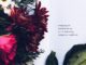 A beautiful floral arrangement alongside an introspective poem on an open book.