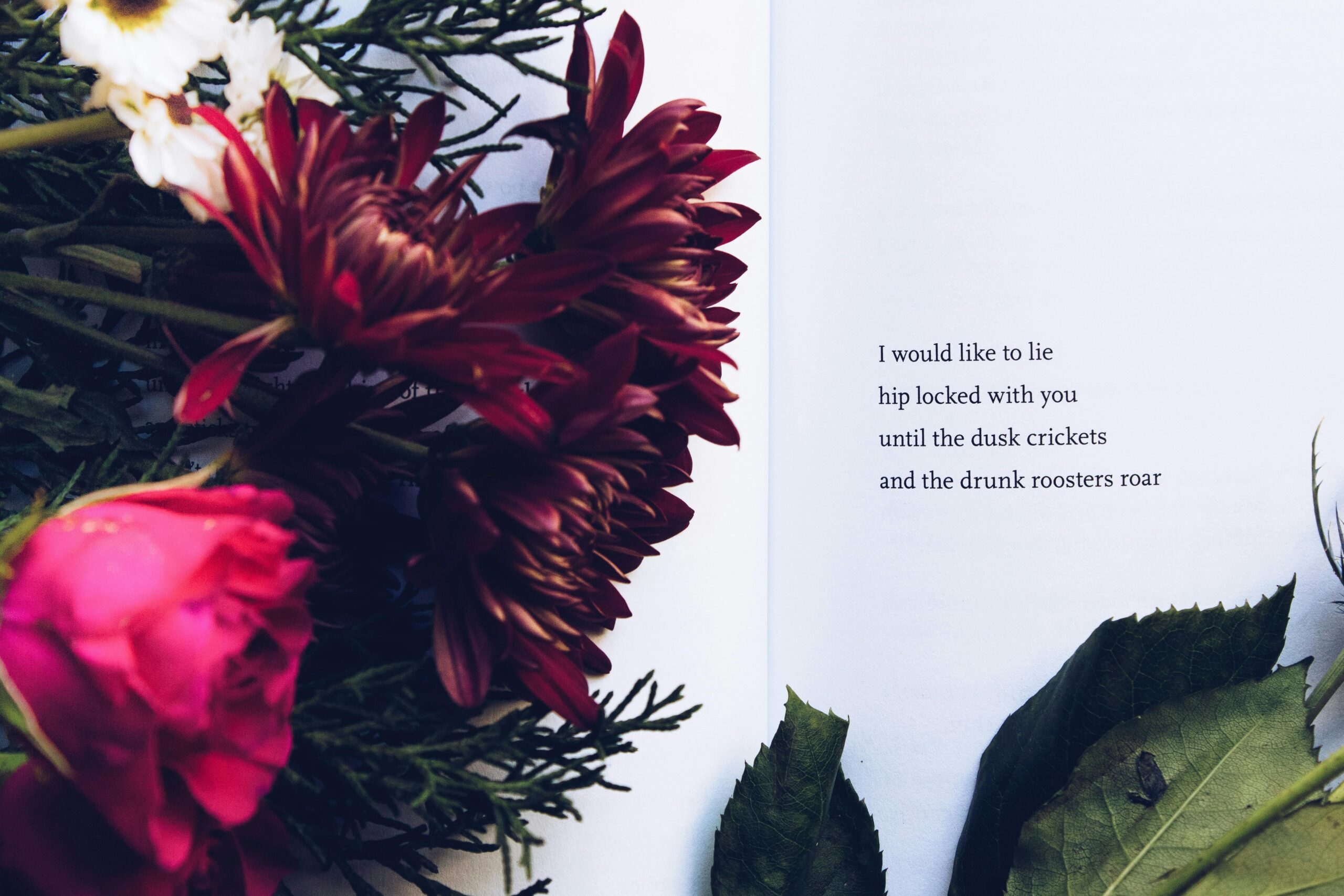 A beautiful floral arrangement alongside an introspective poem on an open book.
