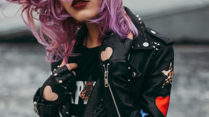 Stylish woman with purple hair in a studded leather jacket. Edgy and modern fashion.