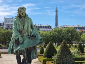 Elegant statue in Paris garden with Eiffel Tower in the background on a sunny day.