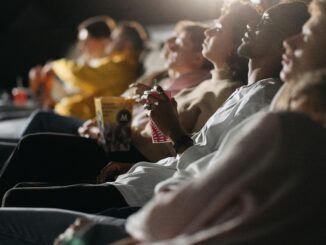 Group of friends watching a film in a cinema, sharing a fun movie night experience.